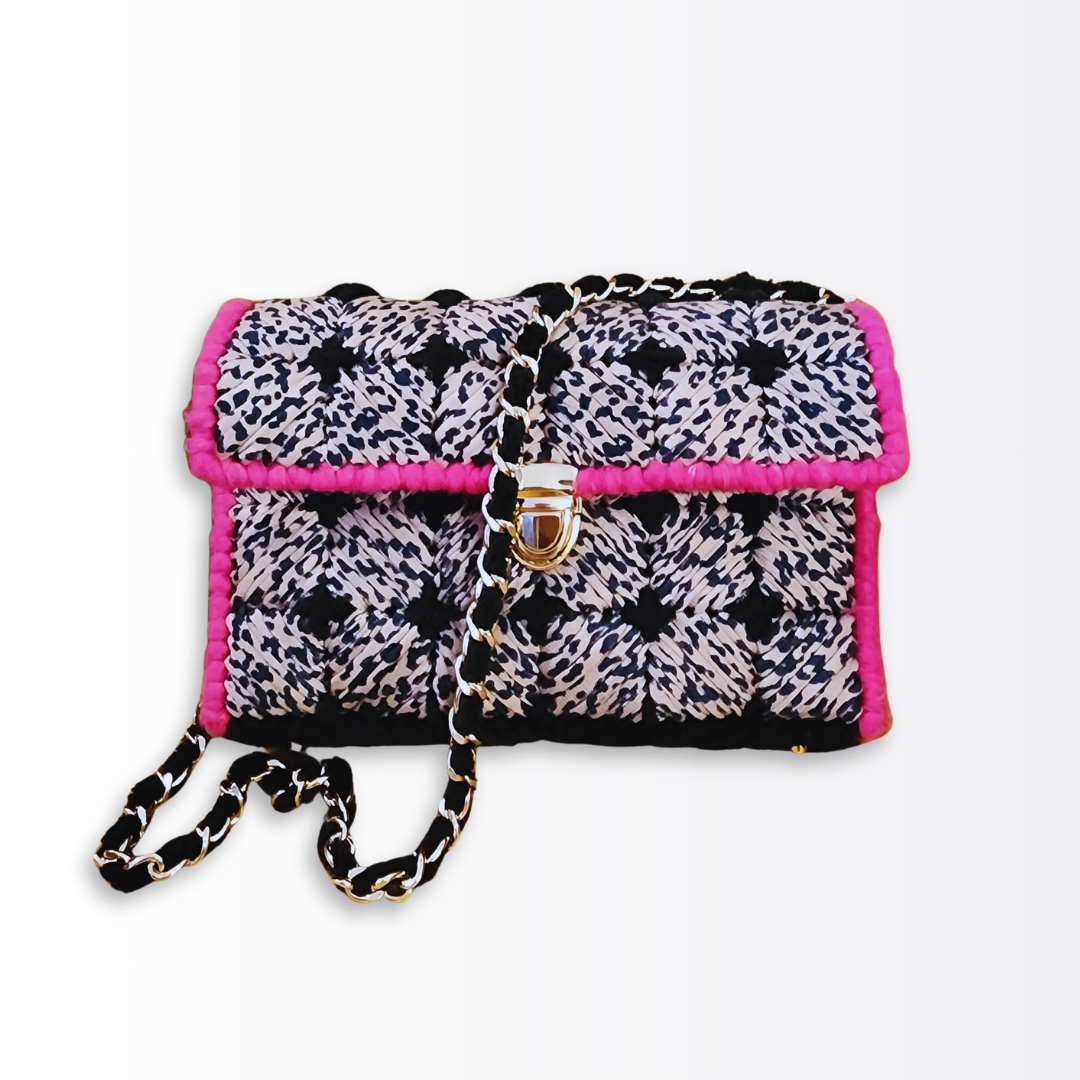 Full front view with the gold woven chain strap draped across the leopard and pink geometric design.