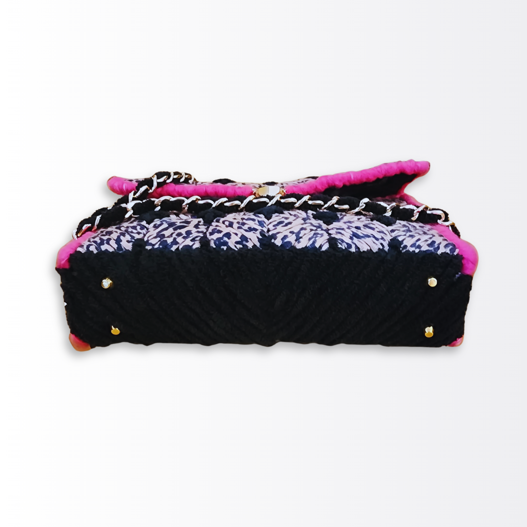Bottom view of the structured leopard clutch showing the plush black chenille base and four protective gold purse feet.