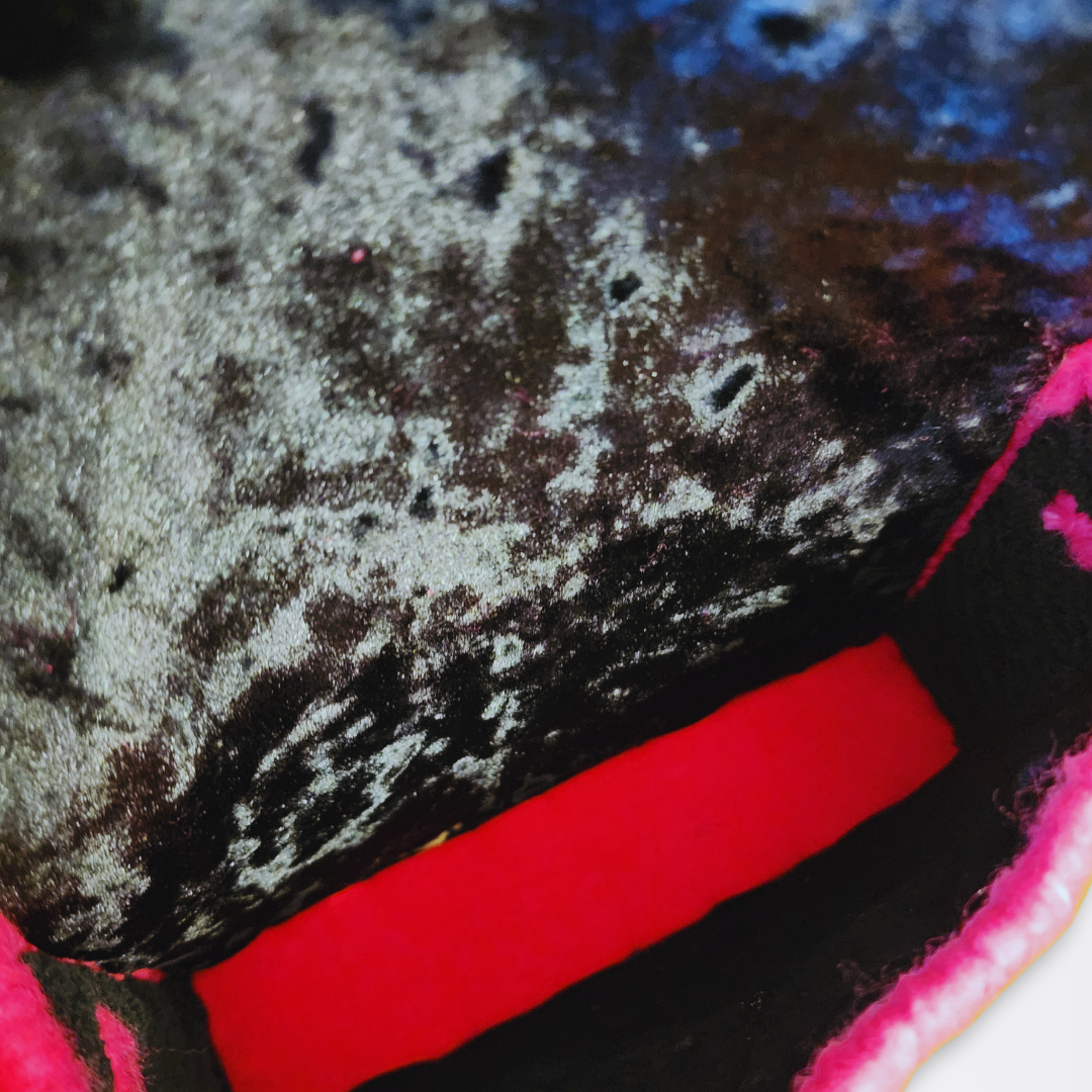 Macro shot of the interior lining showing the contrast between the luxurious black velvet sides and the hot pink cotton bottom.