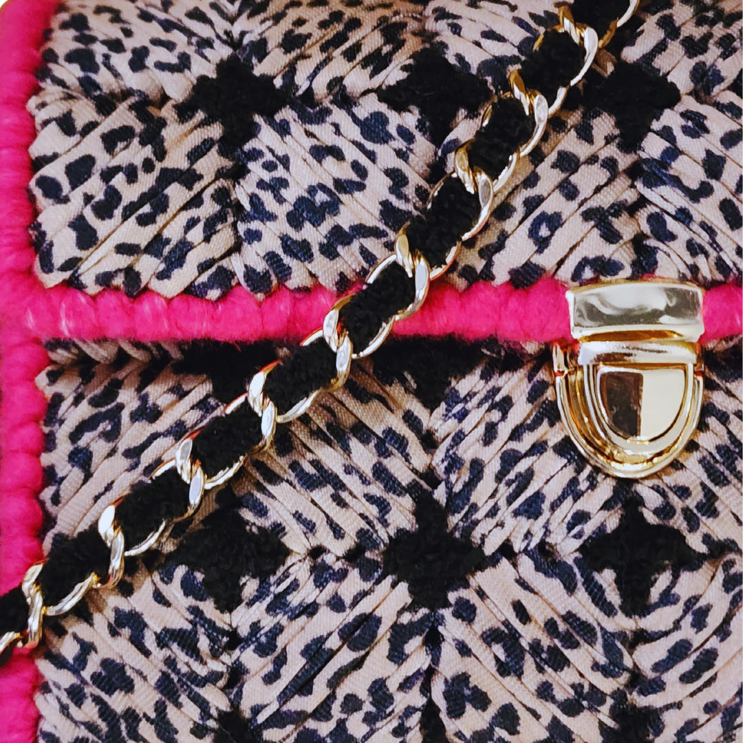 Close-up of the leopard print t-shirt yarn and the structural black cross-stitch detailing at the checkerboard intersections.