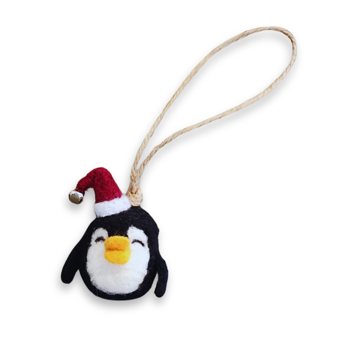 A front view of the smiling felted penguin bobble, wearing a red Santa hat with a bell, and suspended by a jute loop.