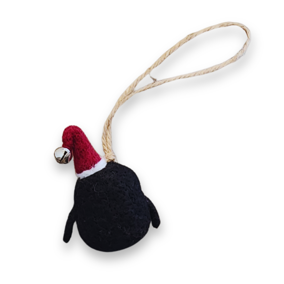 The backside of the penguin bobble, showing the black wool body, the red Santa hat with a silver bell, and the durable jute string hanger.