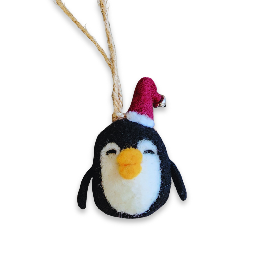 A clear, front-facing image of the needle-felted penguin's face, showing its happy expression, orange beak, and festive red hat.