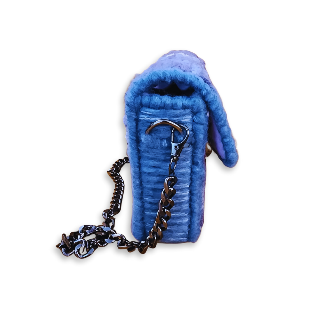 Side profile view of the Galaxy Checker Mini Clutch highlighting the 2-inch depth and the lobster claw attachment on the gunmetal chain strap.