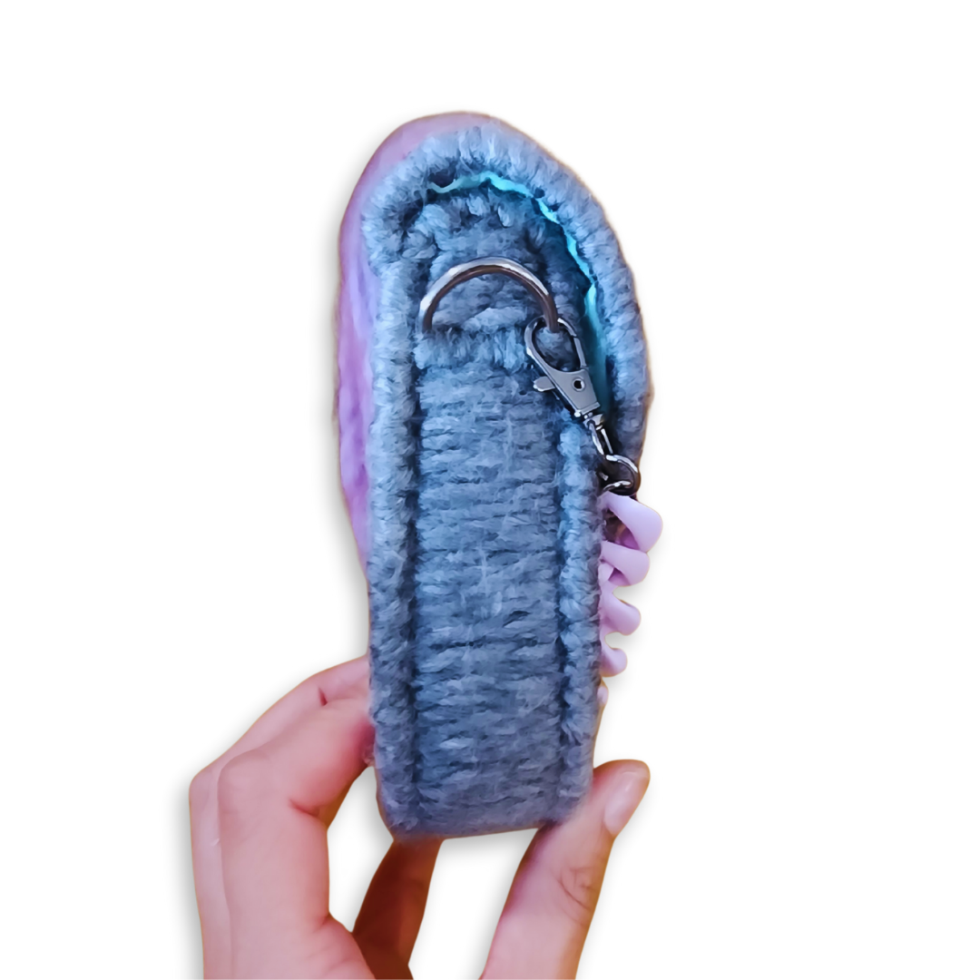 Side profile of the mini saddlebag demonstrating its 1.75-inch depth and rigid internal frame. The gunmetal hardware and lobster claw attachment for the removable strap are visible.