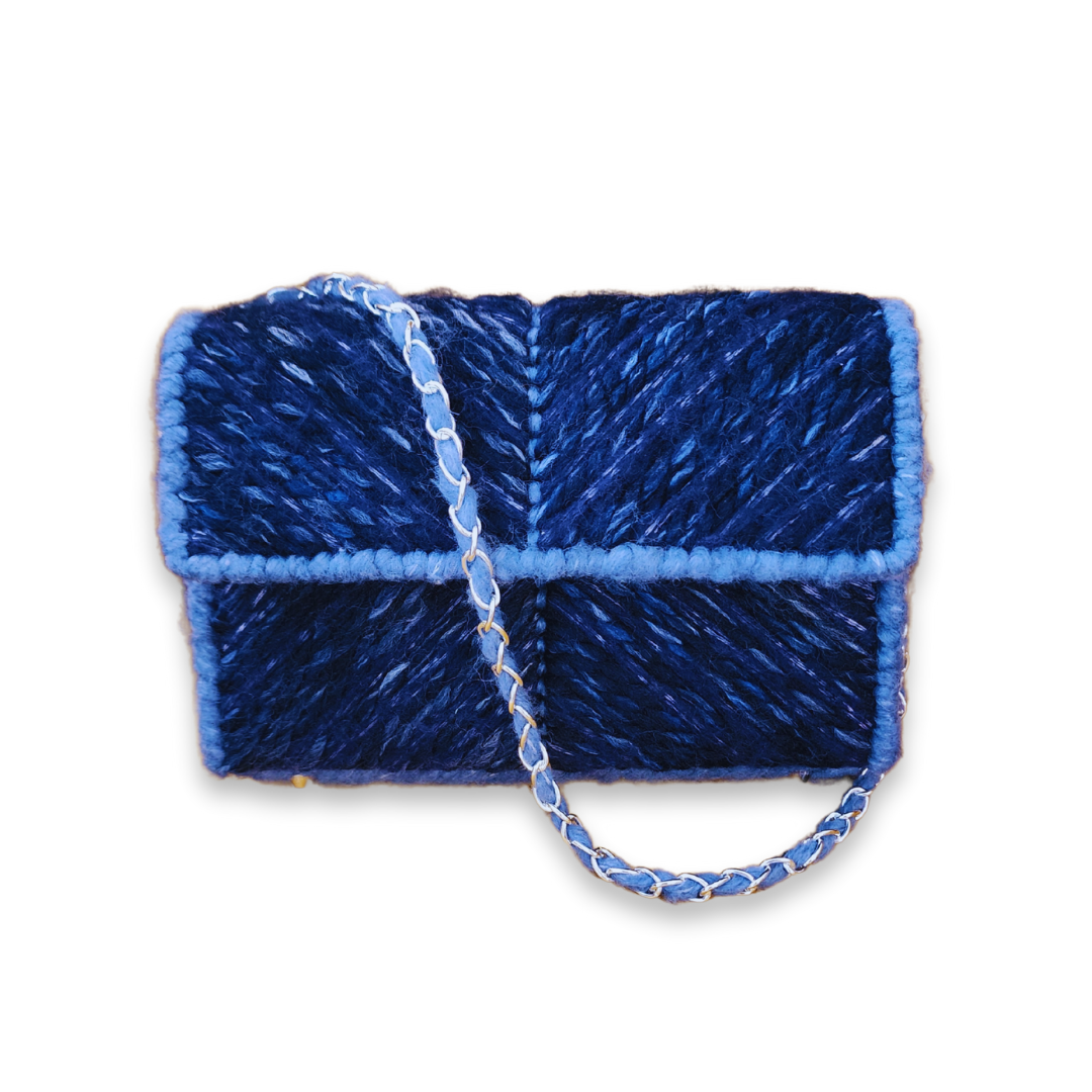 Front view of the Midnight Navy Chevron Mini Clutch highlighting the dual-navy yarn chevron stitch pattern and a 21-inch silver chain strap with light blue yarn woven through the links.