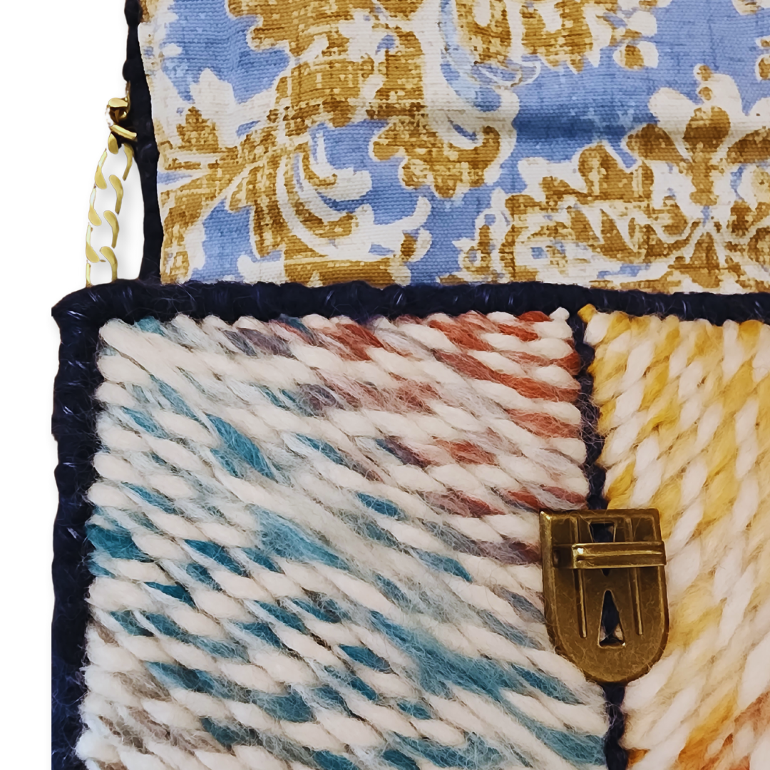 Extreme close-up of the Navy Rainbow Patchwork Clutch highlighting the texture-rich design of the patchwork stitch pattern and the ornate bronze hardware.