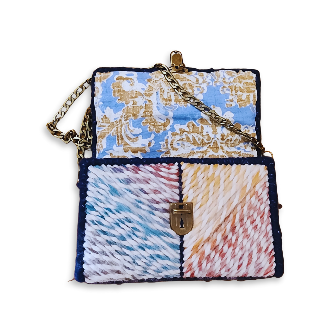 The Navy Rainbow Patchwork Clutch opened to reveal the hand-sewn blue and tan upholstery fabric lining. This view emphasizes the attention to detail and professional bespoke finishing.