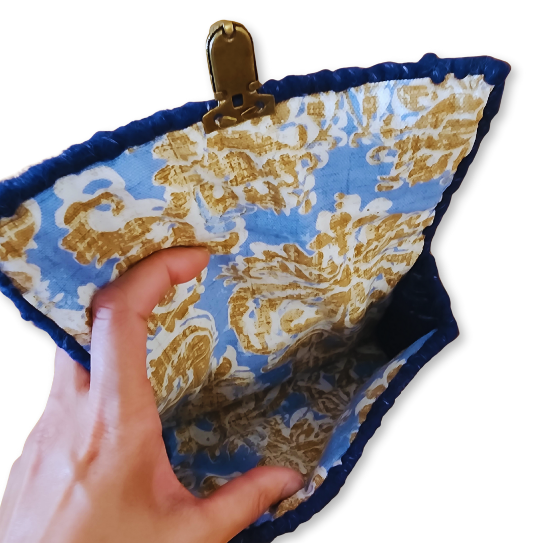 Interior detail shot of the Navy Rainbow Patchwork Clutch showing the sturdy upholstery lining and the secure bronze hardware attachment for the internal frame.