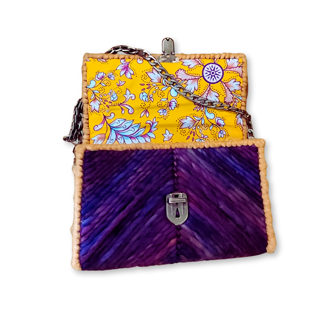 Interior view of the Purple Chevron Clutch opened to reveal a vibrant hand-sewn golden honey cotton lining with an ornate floral design. The image highlights the structural integrity of the rigid internal frame.