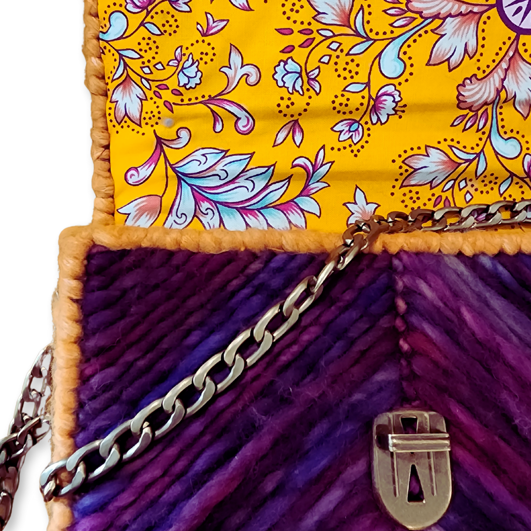 Macro shot of the hand-dyed merino wool texture and the ornate bronze push-lock, emphasizing the attention to detail in this whimsical statement bag.