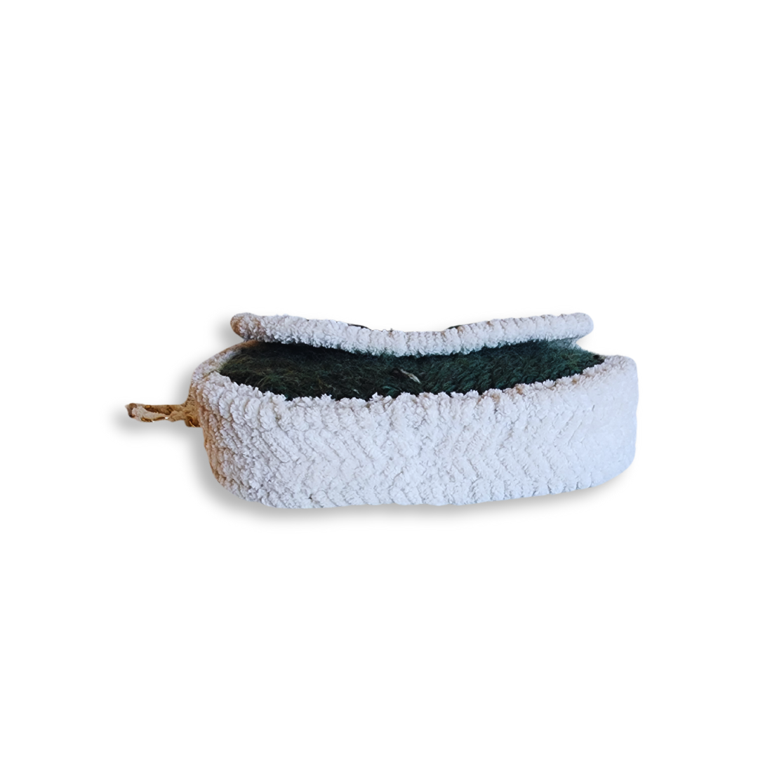 A bottom view of the small, compact saddlebag, showing its depth and the thick white chenille trim along the border.