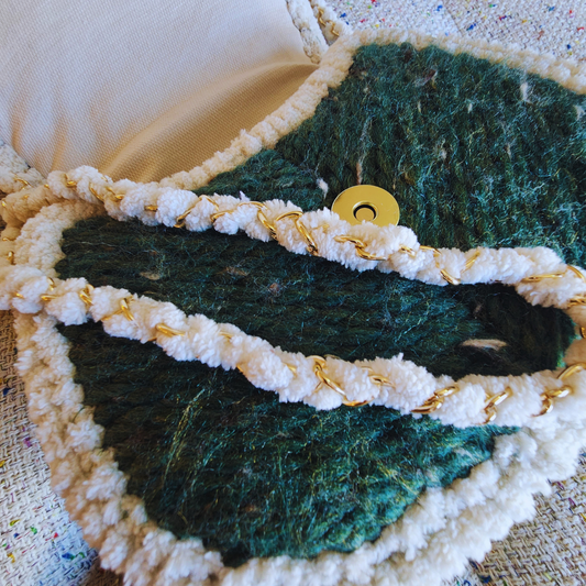 An extreme close-up of the bag's textured flap, showing the gold magnetic clasp and the woven strap, which is a gold chain wrapped in white chenille yarn.