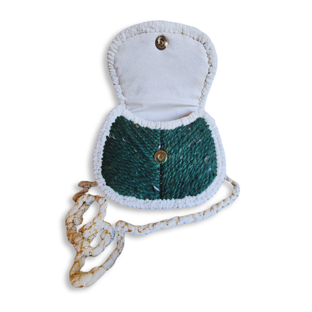 The saddlebag is shown open, revealing the cream-colored fabric lining and the magnetic clasp closure on both the bag body and the inside of the flap.