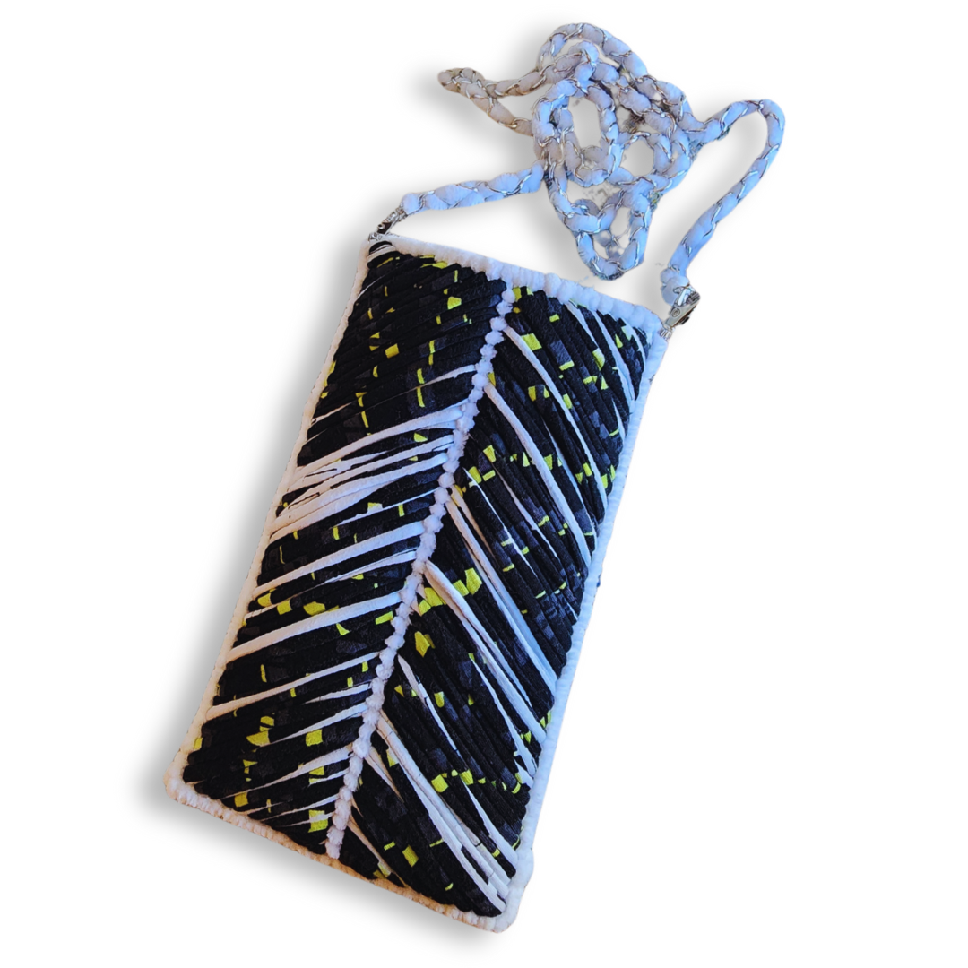 A full view of the elongated phone purse, showcasing the black, white, and neon yellow embroidered chevron pattern and the white woven chain crossbody strap.