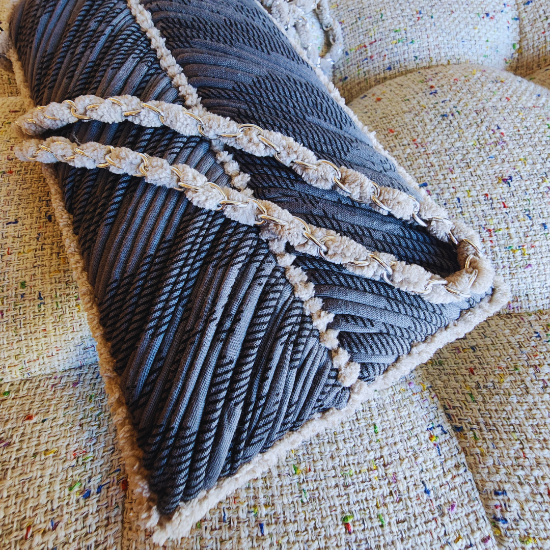 A close-up shot of the gray embroidered phone purse, highlighting the intricate chevron stitch pattern, the soft beige chenille trim, and the woven strap detail.