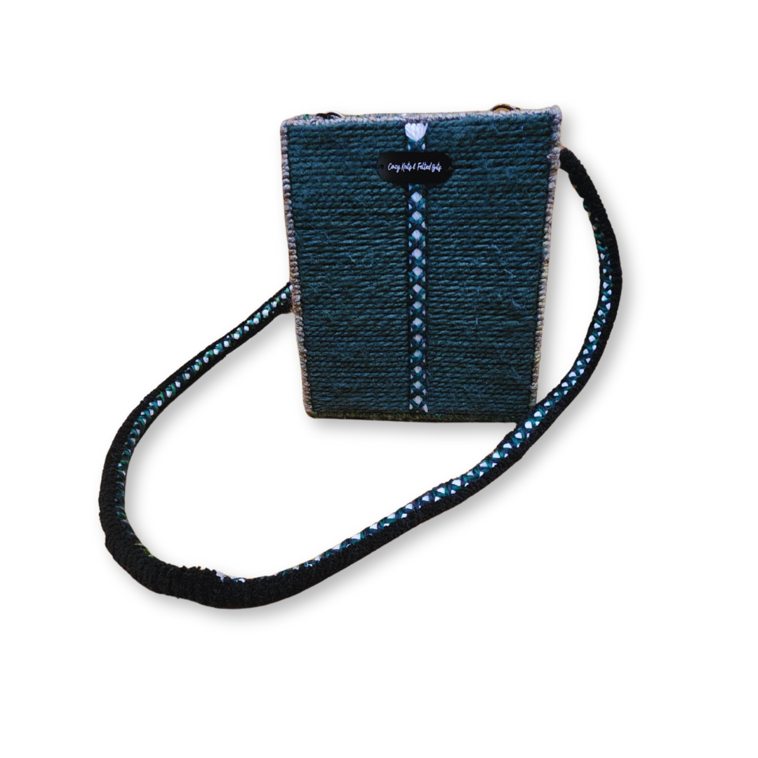 A full frontal view of the embroidered crossbody bag, highlighting the dark green yarn texture and the distinctive white/multicolor central braided stripe design.