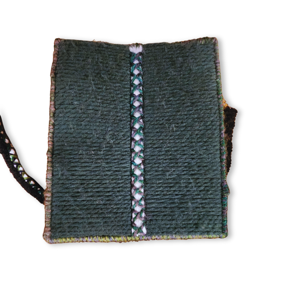 A close-up of the bag's exterior, emphasizing the tight, durable embroidery and the central white, green, and purple multicolor braided vertical stripe.