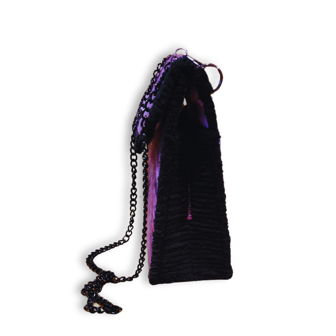 A side view of the embroidered shoulder bag, highlighting the structured 3.5" depth and the attached black chain strap.