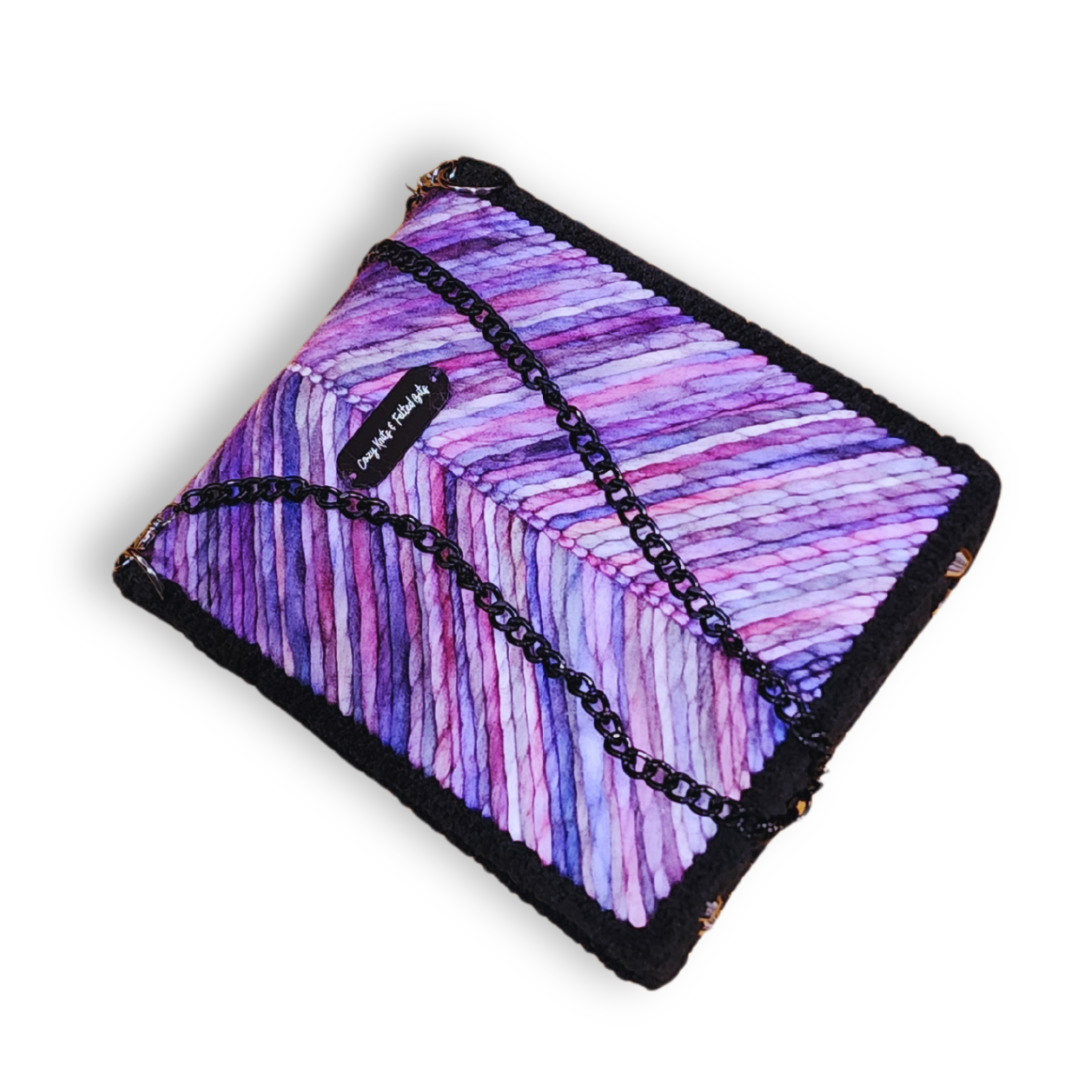 An overhead view of the bag, featuring the beautiful lavender ombre wool texture and the black chain strap draped over the top.