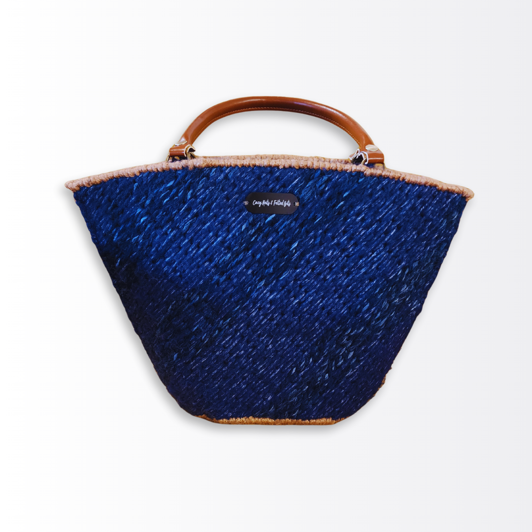 Front-facing shot of the Deep Sea Scalloped Tote emphasizing the wearable architecture concept and the sophisticated contrast between navy fiber and caramel leather.