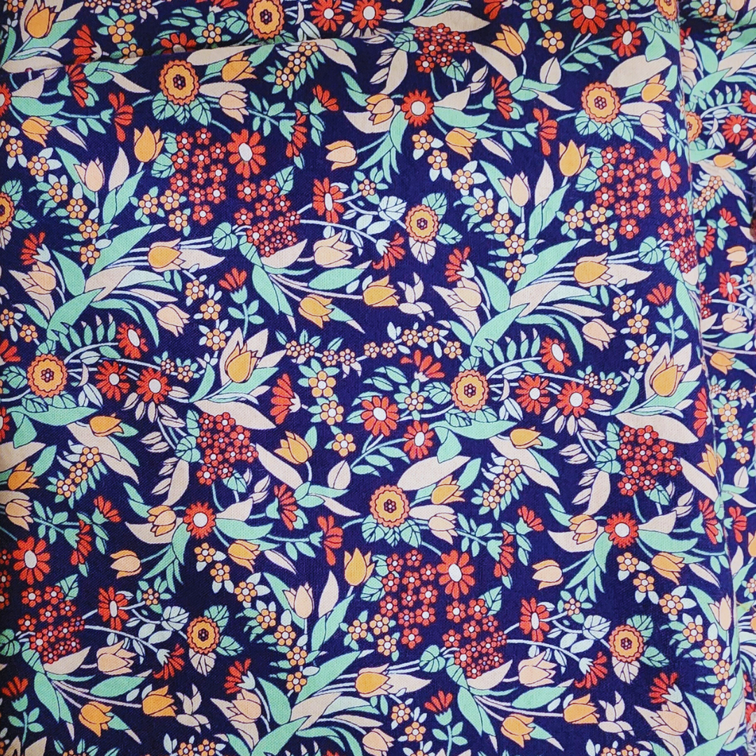 Close-up of the hand-sewn multicolored floral cotton lining, emphasizing the bespoke finishing and whimsical interior design of the flagship tote.