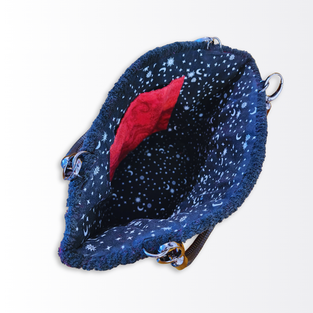 Interior view of the opened tote showcasing the hand-sewn celestial moon and star lining and the dedicated crimson internal pocket.