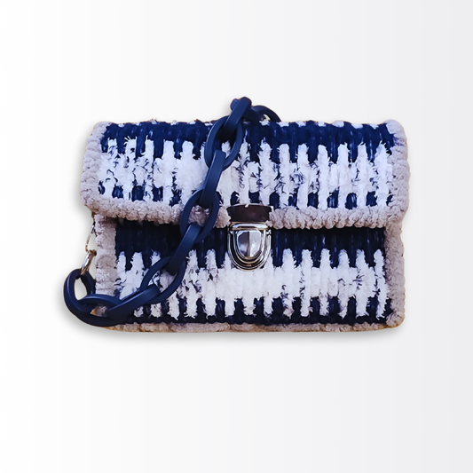Front view of the Deep Sea Mosaic Mini Clutch ($105) featuring a rhythmic two-tone pattern of navy blue fluffy yarn and seaside chenille, accented by a matte navy chunky acrylic chain handle.
