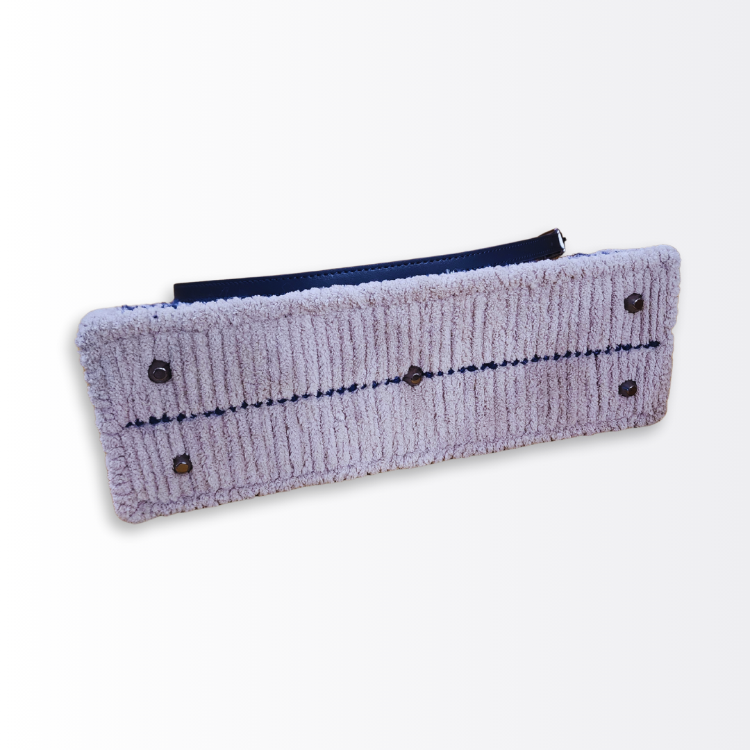 Bottom view of the hand-embroidered crossbody base showing five protective black gunmetal purse feet and high-density grey fiber finishing.
