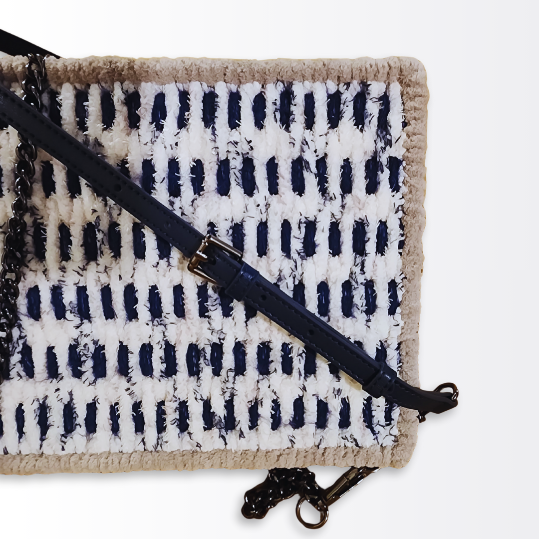 Macro detail of the adjustable navy leather strap and gunmetal buckle hardware against the textured navy and seaside chenille mosaic pattern.