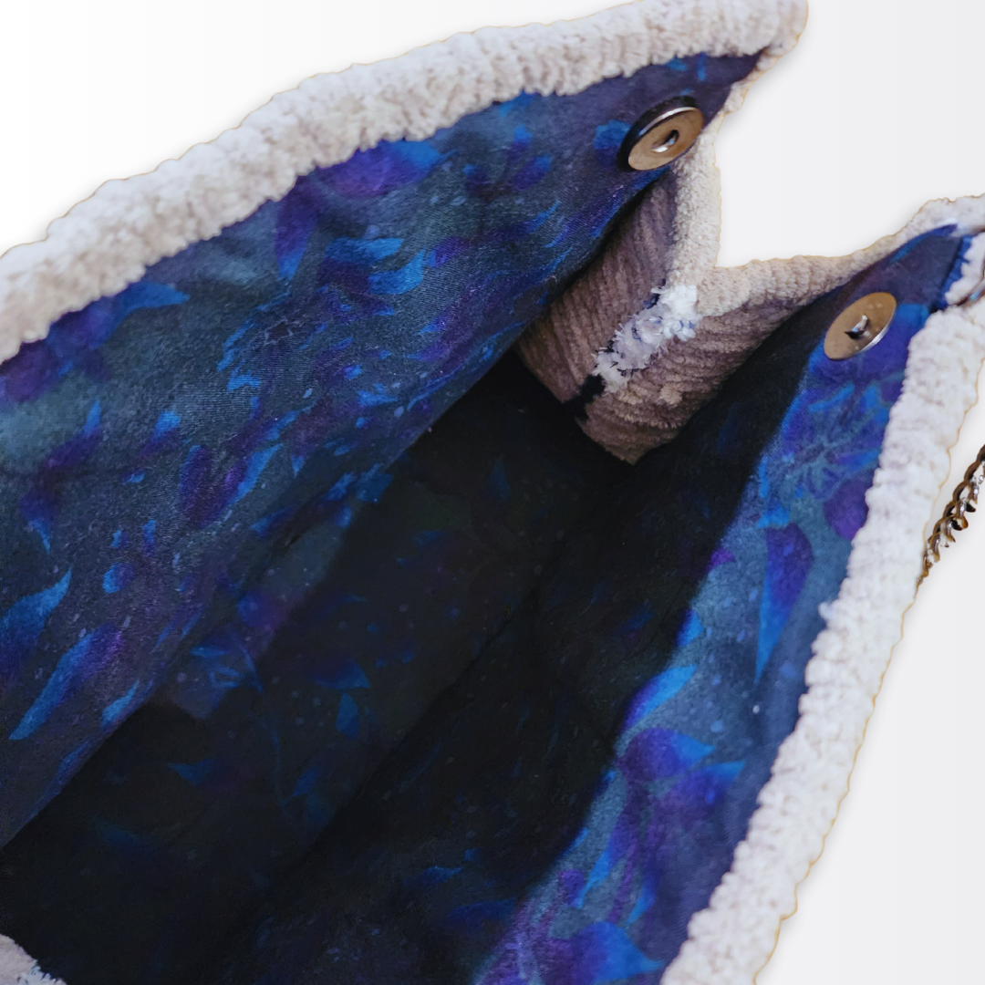 Interior view of the opened crossbody revealing the hand-sewn galaxy-print cotton lining (deep purple/blue with stars) and the secure magnetic snap closure.