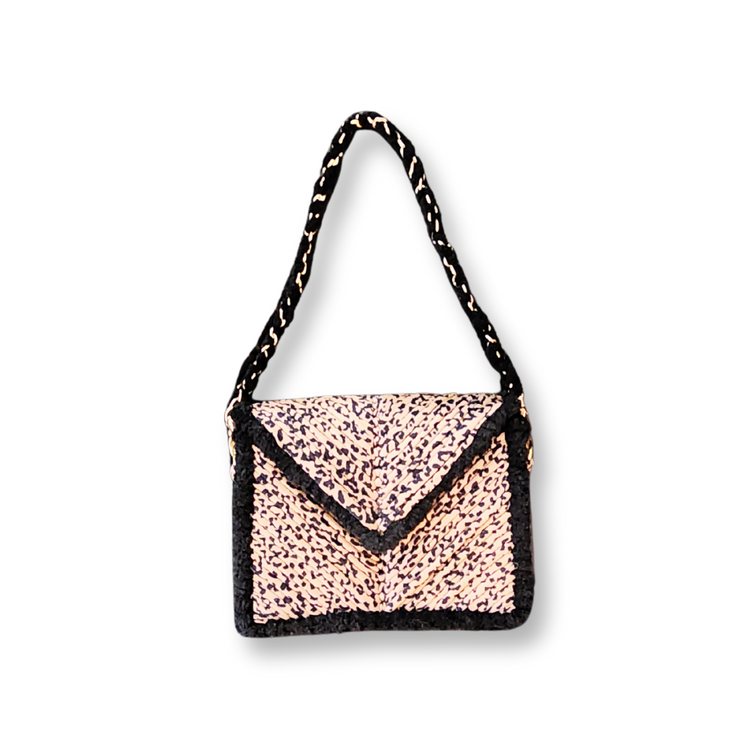 A front view of the clutch, showcasing the pointed, envelope-style flap in Leopard Print embroidery with a black chenille edge and a short shoulder strap.
