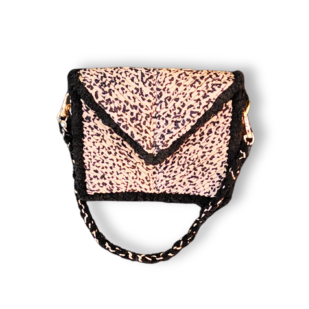 An overhead view of the clutch with the strap folded into a handle, highlighting the detailed Leopard Print embroidery and black chenille border.