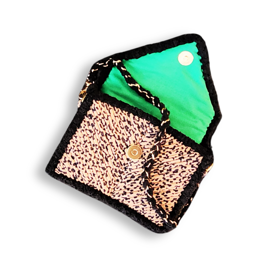 The clutch is shown partially open, revealing the bright neon green fabric lining and the gold magnetic clasp closure on the Leopard Print flap.