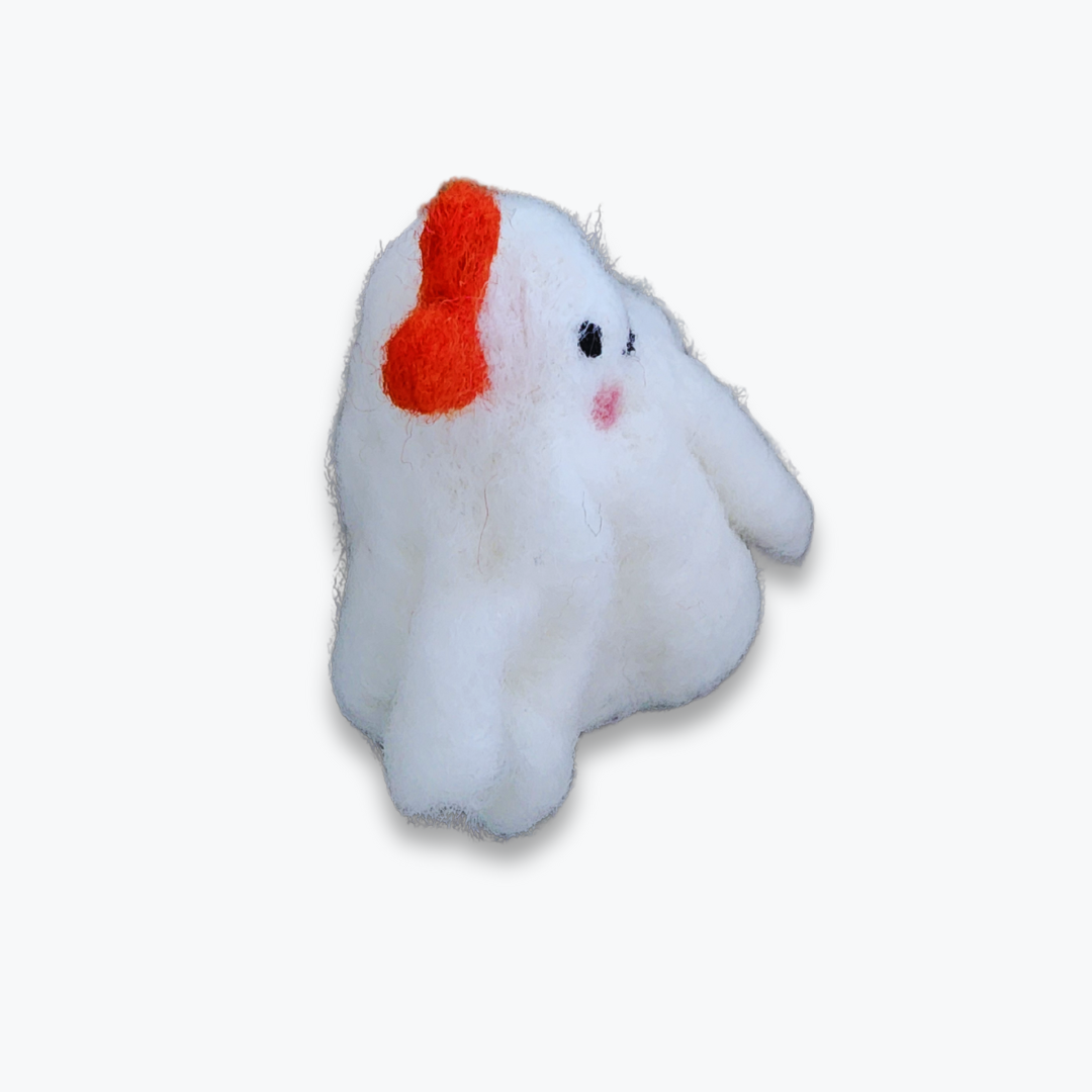 A large handmade felted ghost figurine with an orange bow, a cute smiling mouth, and pink cheeks, viewed from a side angle against a plain white background.