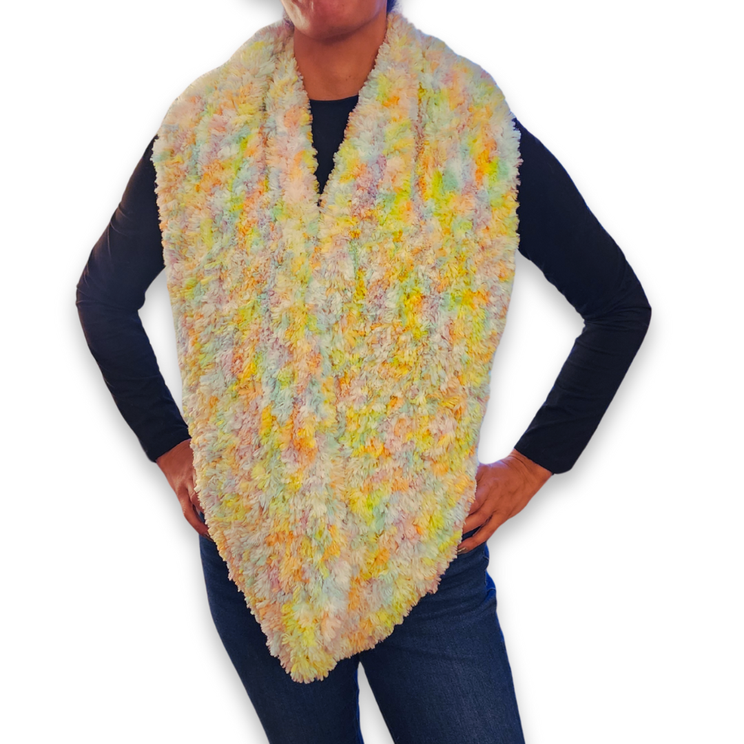 A person models the multi-colored "sprinkles" faux fur infinity scarf, worn long over the chest, showcasing the playful pastel yarn blend.