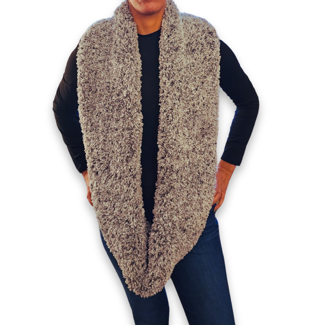A person models the wide stone faux fur infinity scarf, worn long, emphasizing the neutral color and soft, bulky feel.