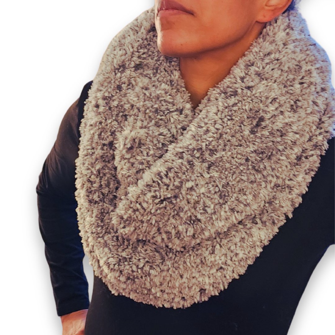 A close-up view of the stone faux fur infinity scarf looped around the neck, highlighting the soft texture of the yarn.
