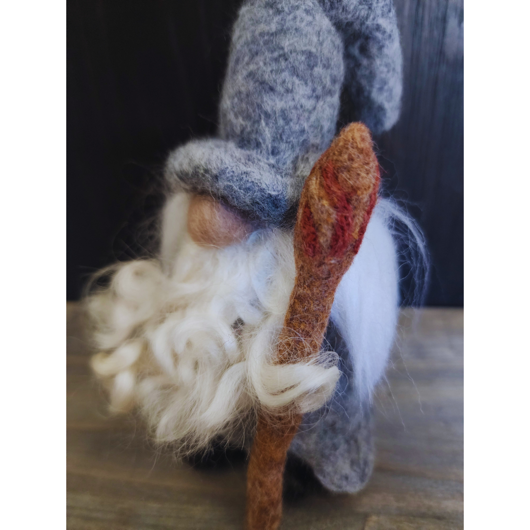 Close-up of needle-felted Gandalf's face, focusing on his long white wool beard and felted staff.