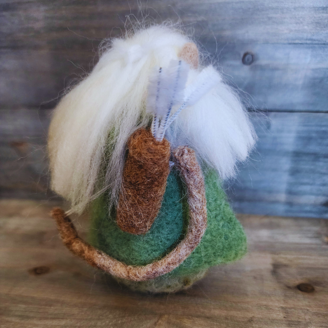 Rear view of the needle-felted Legolas, clearly showing his long white hair, green cloak, and the brown felted quiver and bow slung over his back.