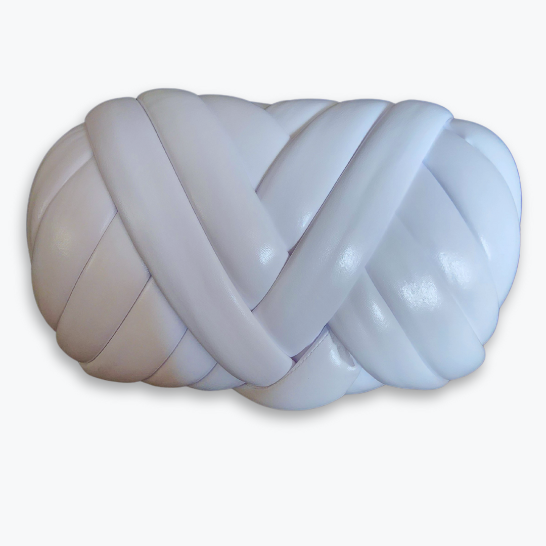A large skein of handmade chunky yarn in matte white, showing its thick, braided texture.