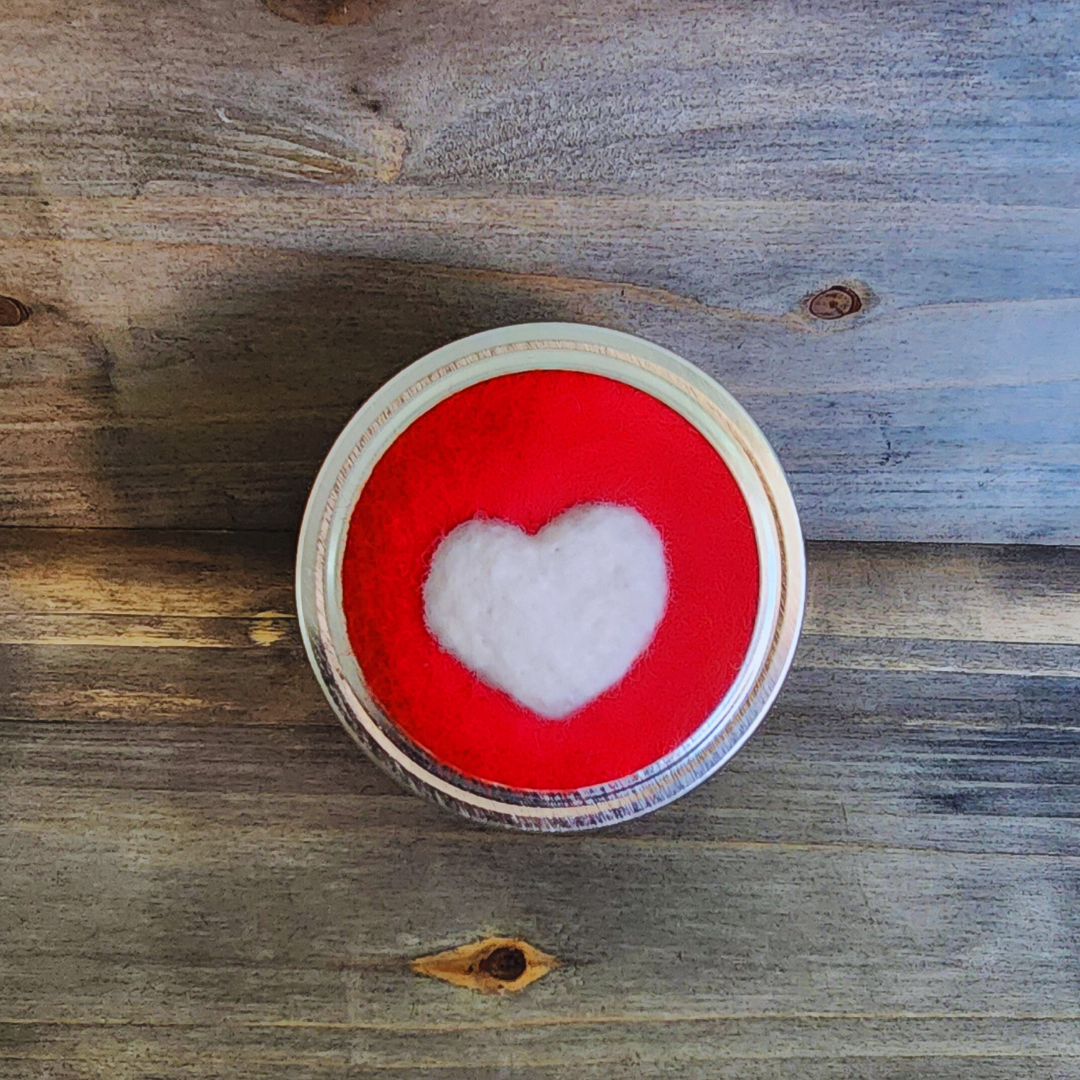 A top-down view of the red and white heart lid resting on a rustic wooden surface.
