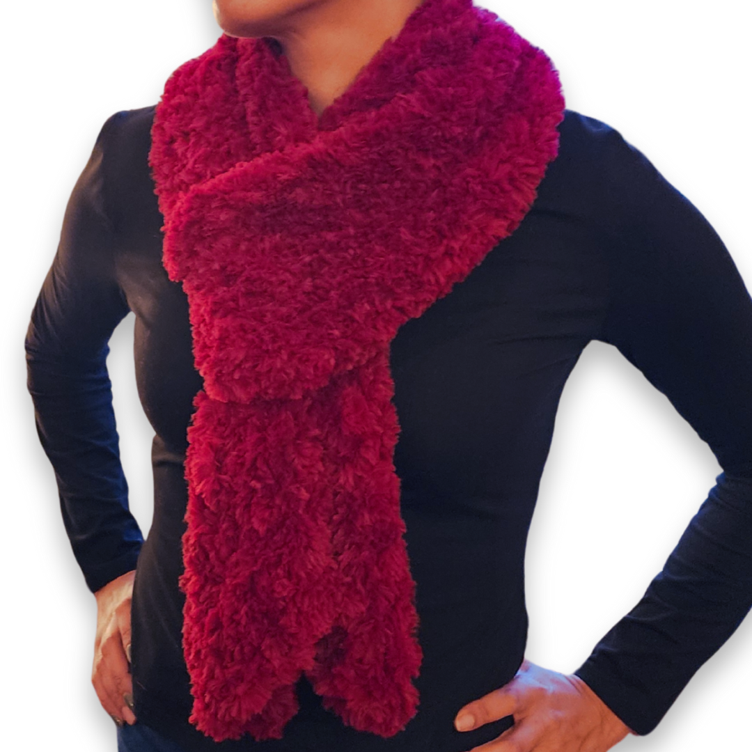 A person models an extra long, plush maroon (deep red) faux fur scarf, wrapped once around the neck and tied in front.