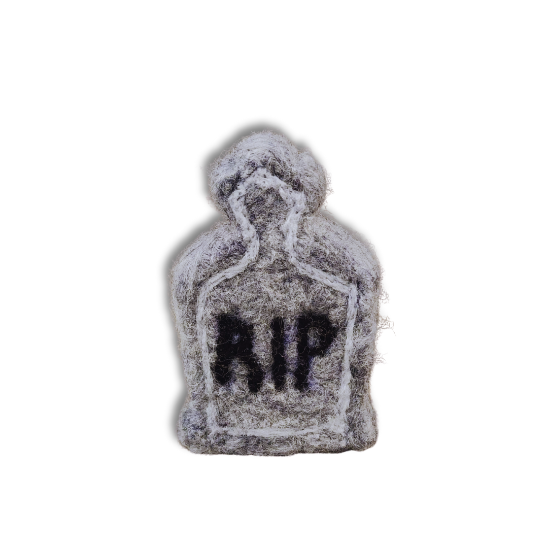 A handmade felted tombstone figurine in gray with a black "RIP" inscription, viewed from the front against a white background.