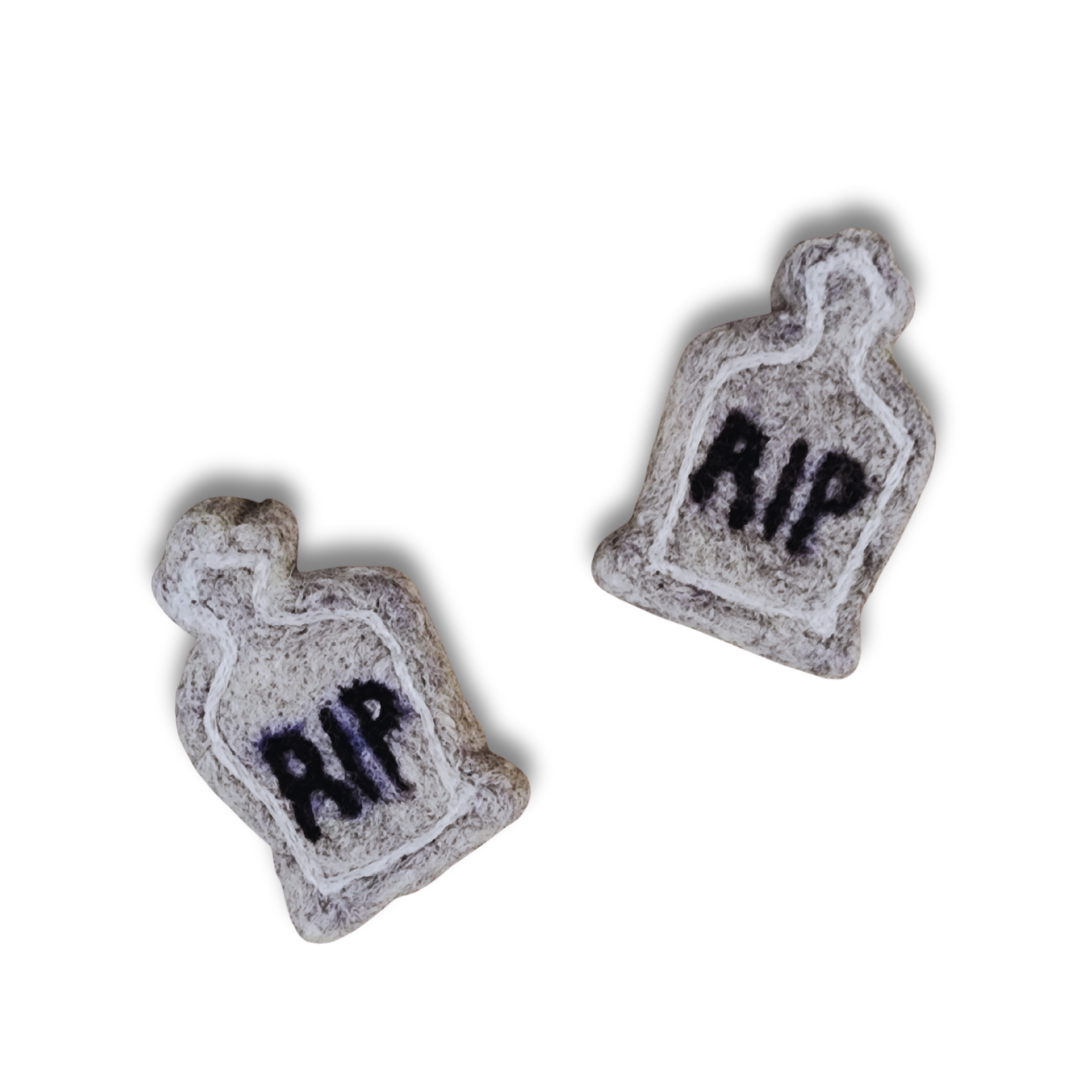 A pair of handmade felted tombstone figurines in gray with black "RIP" inscriptions, viewed from above against a white background.