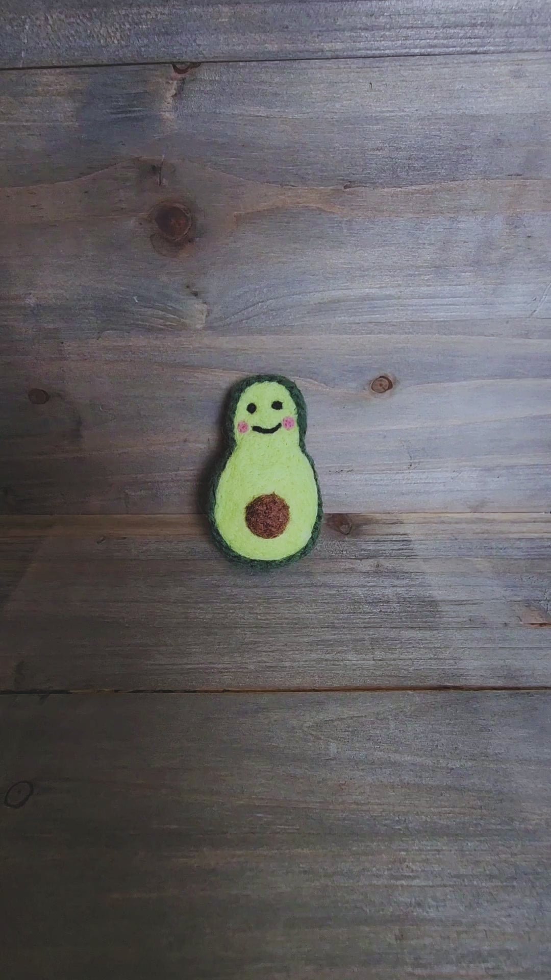 A short video demonstrating the durability of the avocado toy as a pair of hands squeezes and turns it to show the 360-degree felted construction and firm, wool-filled core.